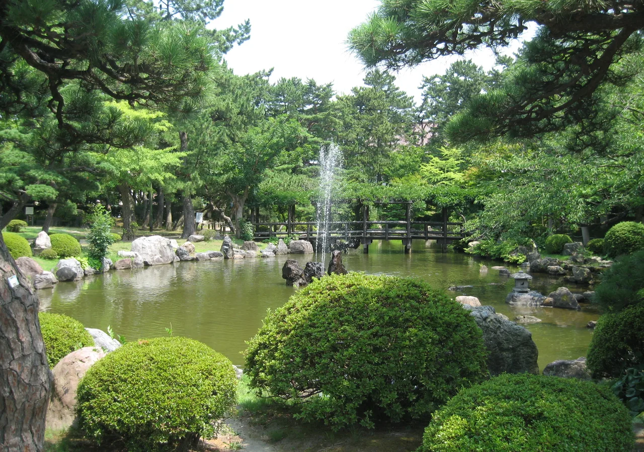 緑に包まれた白山公園の池と噴水
